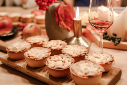 Mini pies lined up by a glass of wine